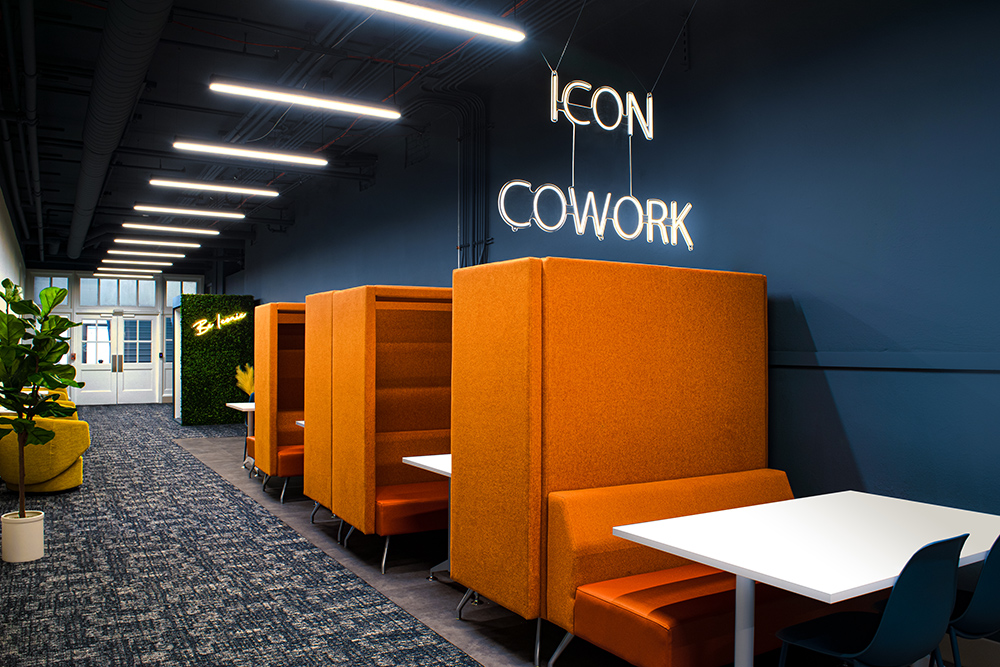 indoor coworking office space with brightly colored orange booths and modern lighting